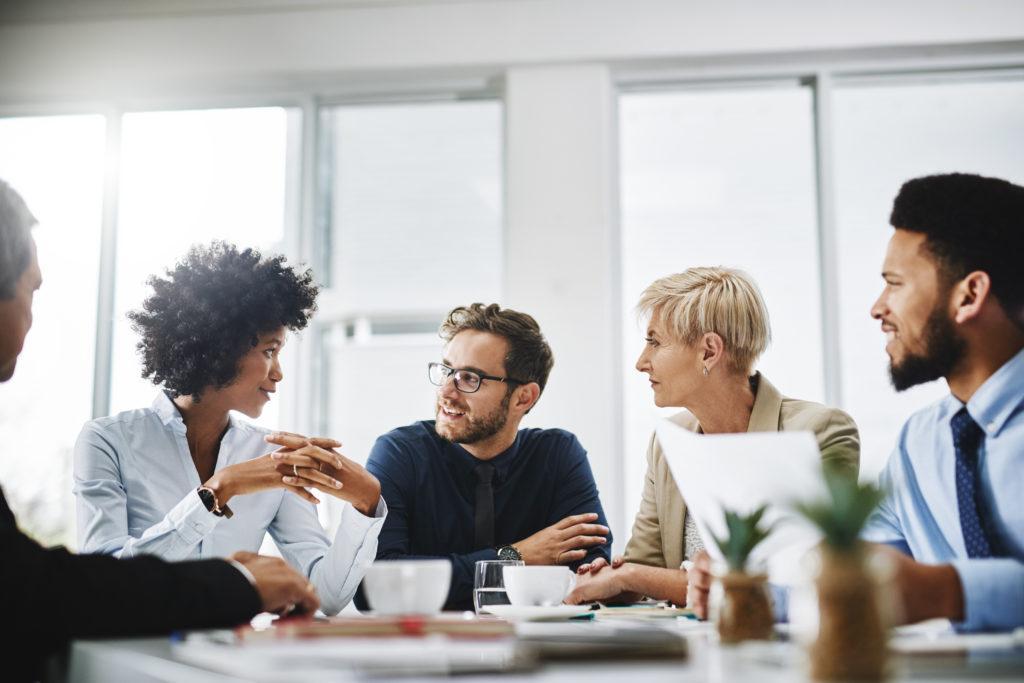 A group of employees having a conversation at a table